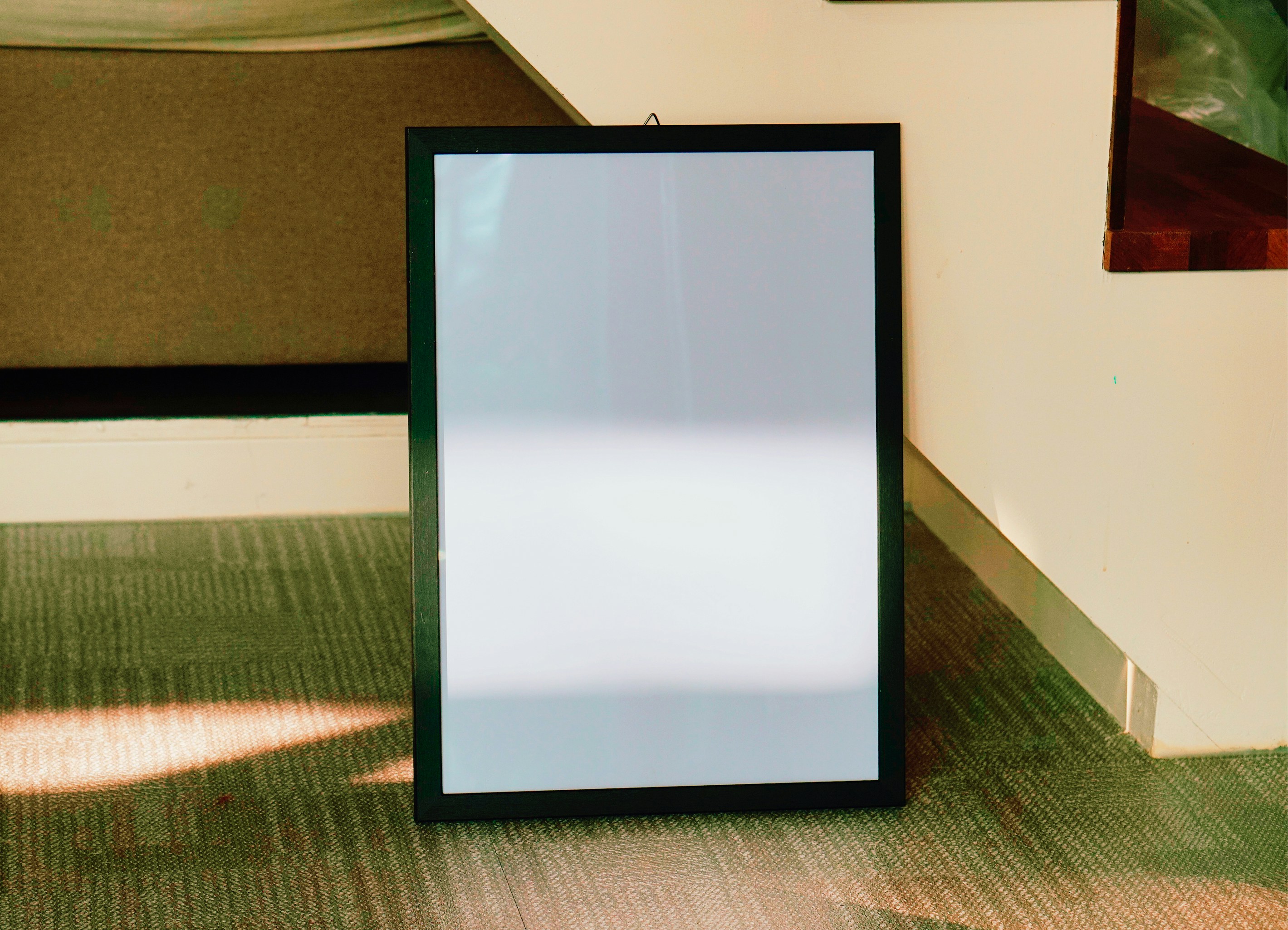 a picture frame sitting on the floor next to a wall